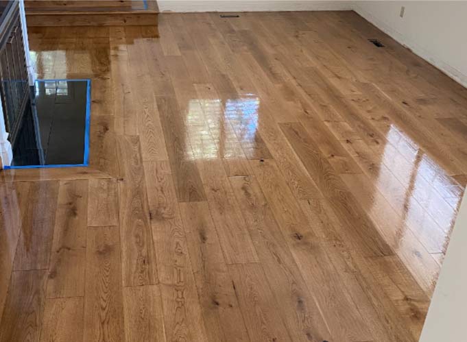 Beautiful light-colored prefinished hardwood flooring installed in a kitchen, showing the seamless transition and final long-lasting aesthetic.