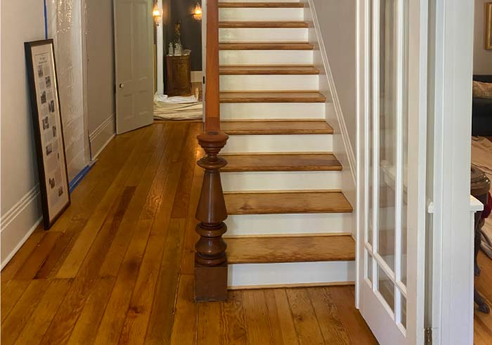 Newly installed wide-plank natural oak hardwood flooring adds warmth and significant property value to a modern living room space.