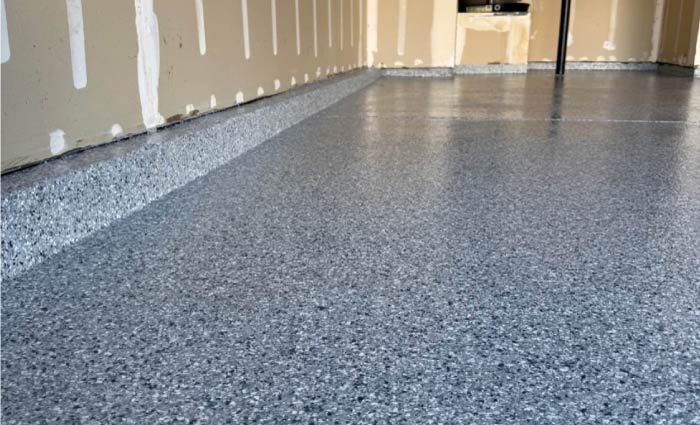 Professional installation of gray flake epoxy garage floor with a smooth, durable finish in Sacramento home