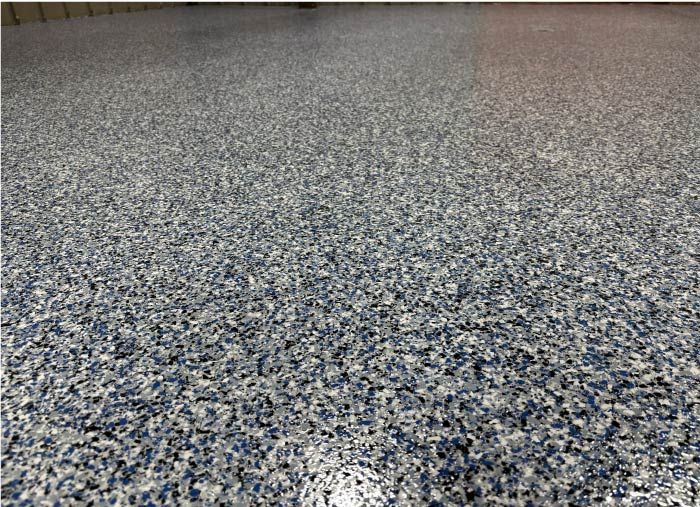Close-up of stunning blue, white, and black vinyl flake epoxy coating on a residential garage floor