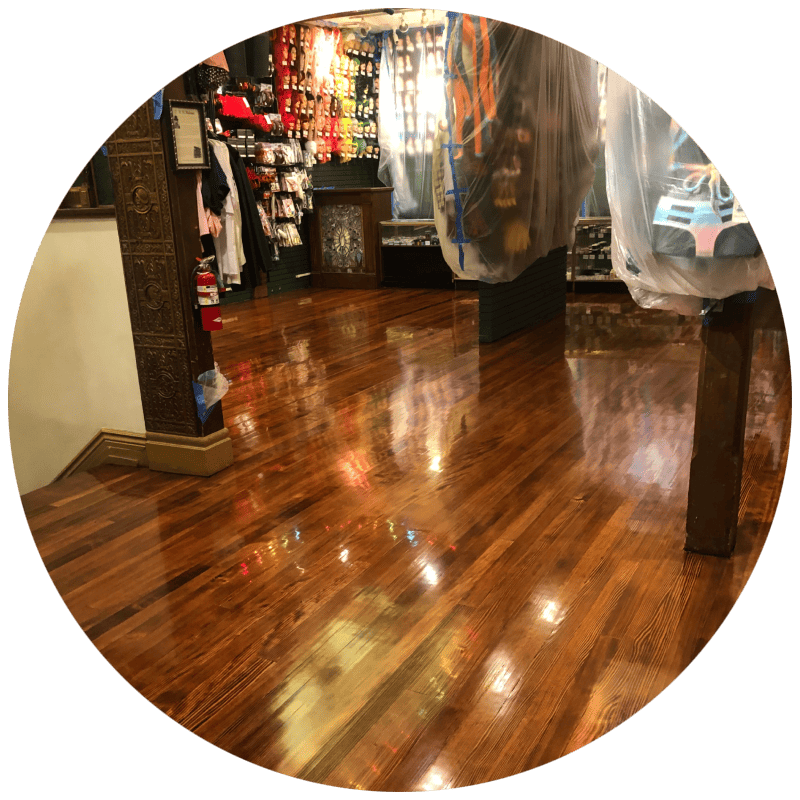 Hardwood floor refinishing - A large room with a newly sanded maple wood floor, showing the light wood grain